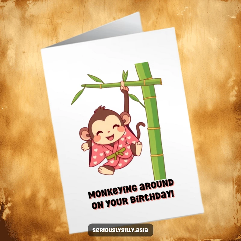 Funny Free Printable birthday card showing a happy cartoon monkey in a kimono swinging from a bamboo stalk.