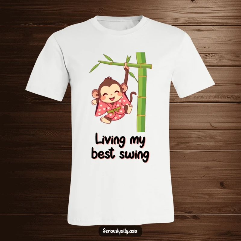 Funny t-shirt featuring a happy cartoon monkey dressed in a bright kimono, swinging from a bamboo stalk.