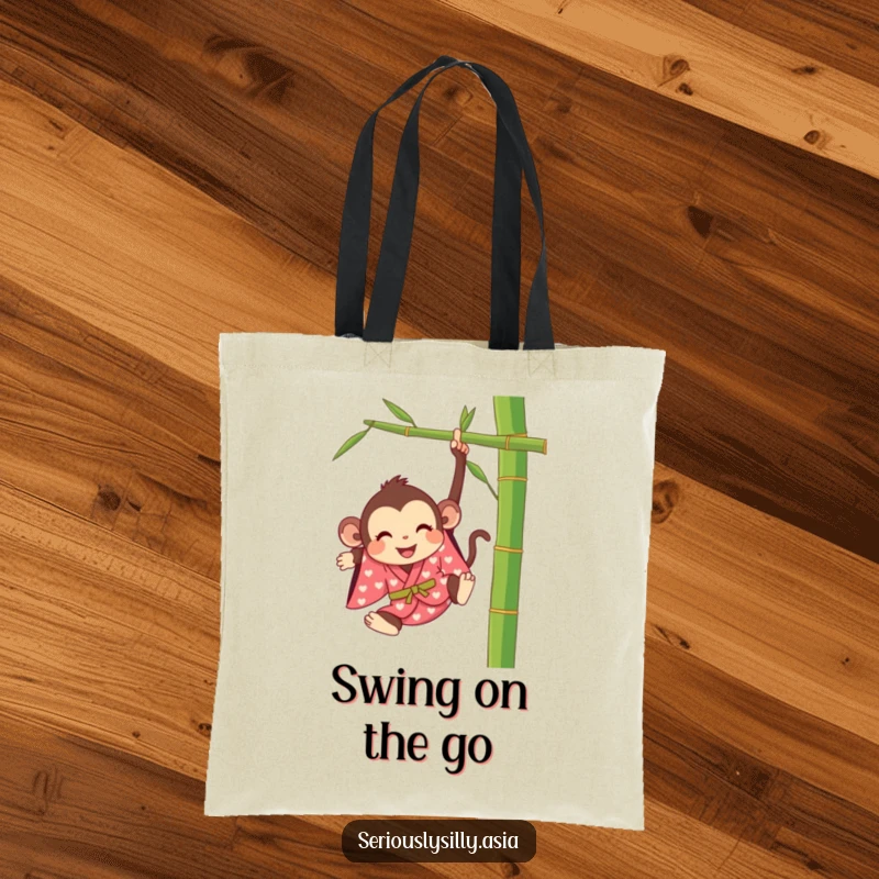 Funny tote bag featuring a happy cartoon monkey in a bright kimono, swinging from a bamboo stalk with delight.